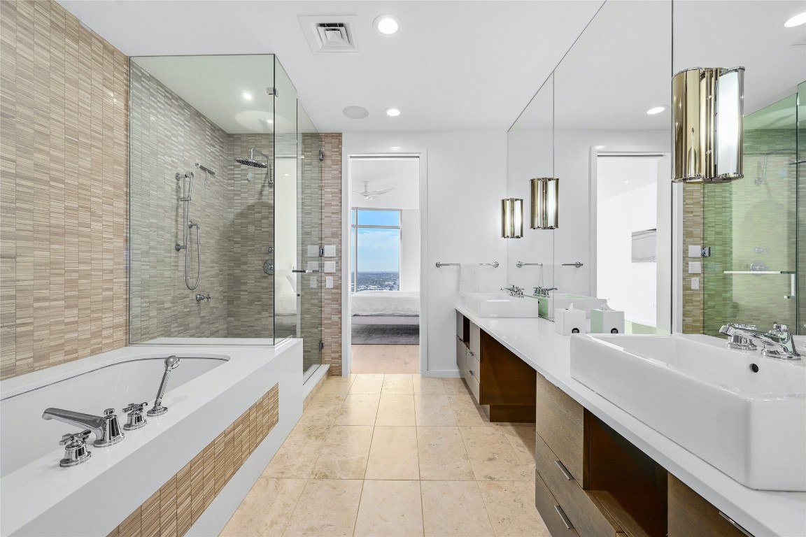 200 Congress Avenue, Unit 32SE Austin, TX 78701 - Photo 17 of 40 a large spacious bathroom with a double vanity sink a mirror and a bathtub