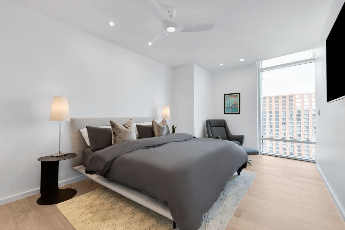200 Congress Avenue, Unit 32SE Austin, TX 78701 - Photo 19 of 40 a spacious bedroom with a bed and a large window