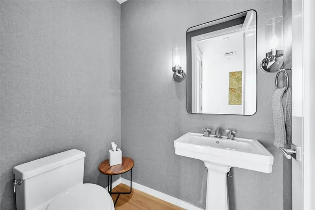a bathroom with a toilet sink and mirror