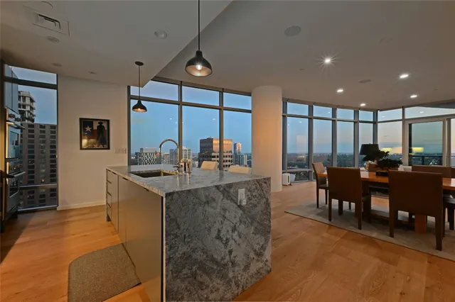 a view of dining room kitchen with stainless steel appliances granite countertop a stove and a dining table