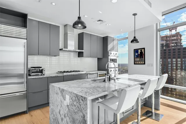 a kitchen with a stove a refrigerator a sink a dining table and chairs