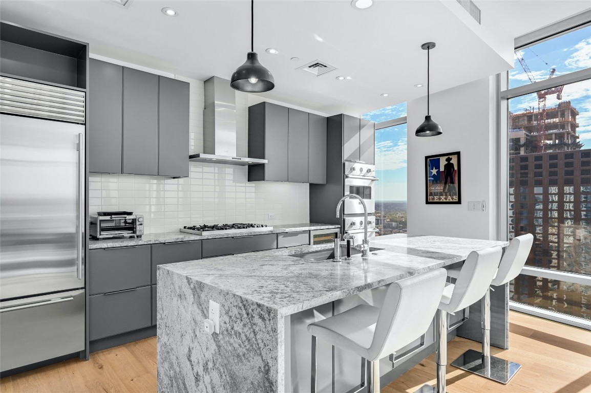 200 Congress Avenue, Unit 32SE Austin, TX 78701 - Photo 7 of 40 a kitchen with a stove a refrigerator a sink a dining table and chairs