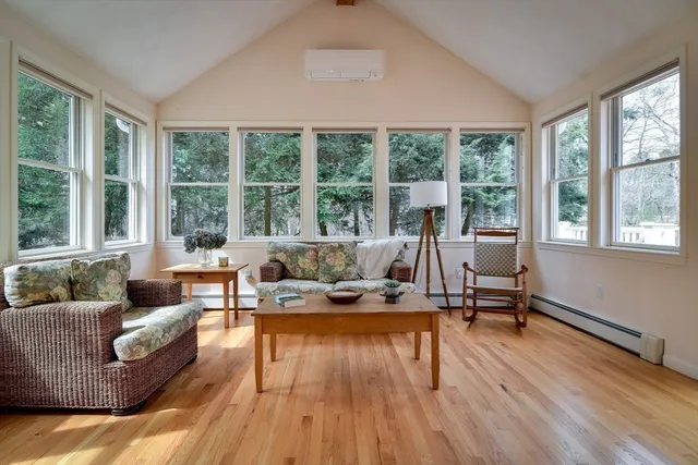 a view of a big room with wooden floor and windows