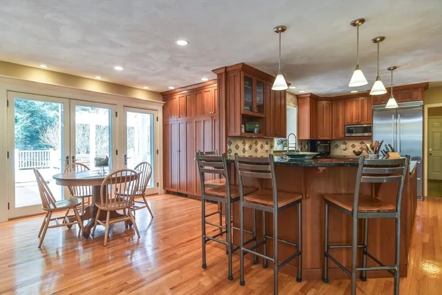 a living room with furniture a large window and wooden floor