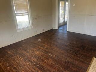 620 South 13th Street Slaton, TX 79364 - Photo 3 of 16 an empty room with wooden floor and windows