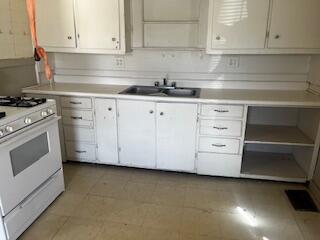 620 South 13th Street Slaton, TX 79364 - Photo 5 of 16 a kitchen with granite countertop white cabinets and white appliances