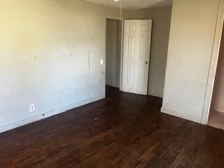 an empty room with wooden floor and door