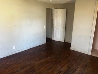 620 South 13th Street Slaton, TX 79364 - Photo 7 of 16 an empty room with wooden floor and door