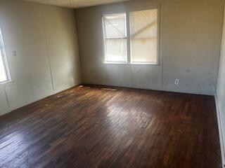 620 South 13th Street Slaton, TX 79364 - Photo 8 of 16 an empty room with wooden floor and windows