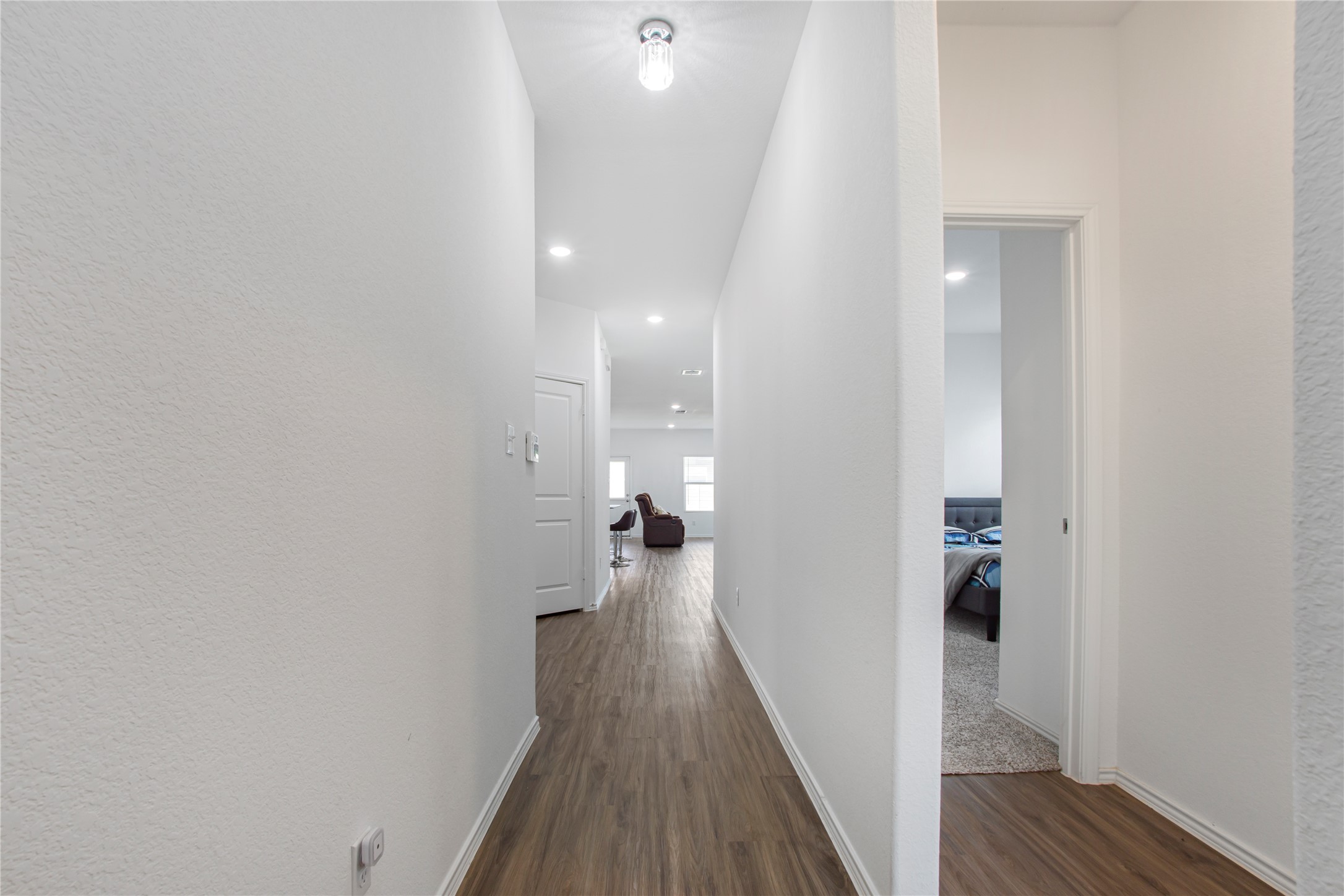124 Cherry Ridge Road Georgetown, TX 78628 - Photo 5 of 23 Long interior hallway featuring wood-finish flooring, recessed lighting, and a ceiling-mounted fixture