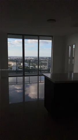 a view of an empty room with a floor to ceiling window