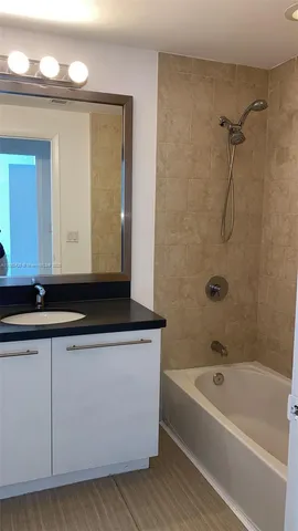 a bathroom with a bathtub a mirror and a sink