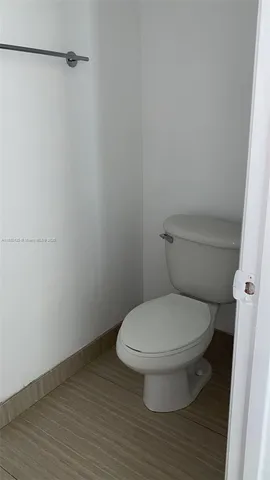 a white toilet sitting next to a shower