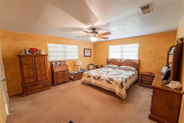 a spacious bedroom with a bed and a chandelier