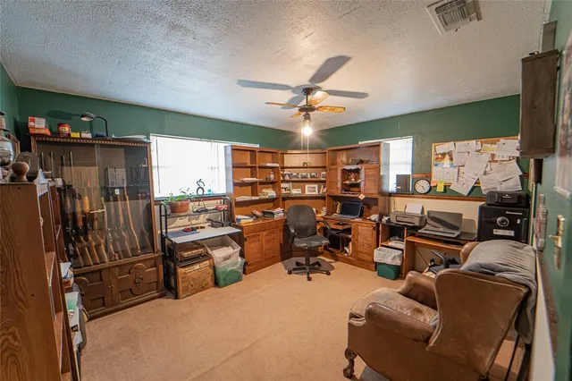 a view of a livingroom with workspace and windows