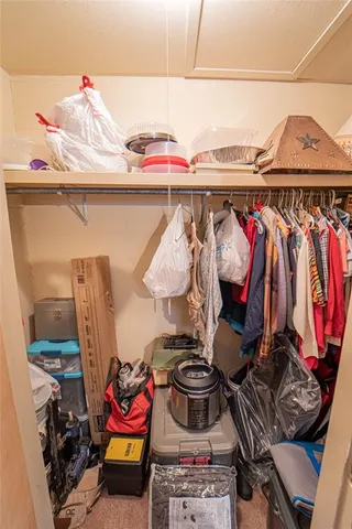 a view of walk in closet with clothes and shoes