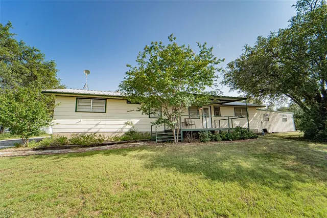 a backyard of a house with table and chairs