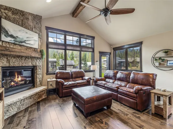 a living room with furniture a large window and a fireplace