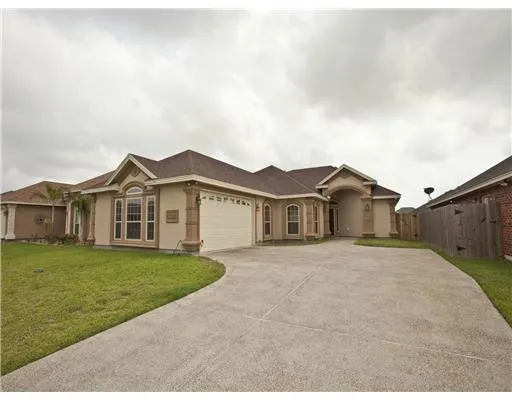 a front view of a house with a garden and yard