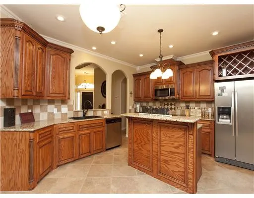 a large kitchen with kitchen island a sink stainless steel appliances and cabinets