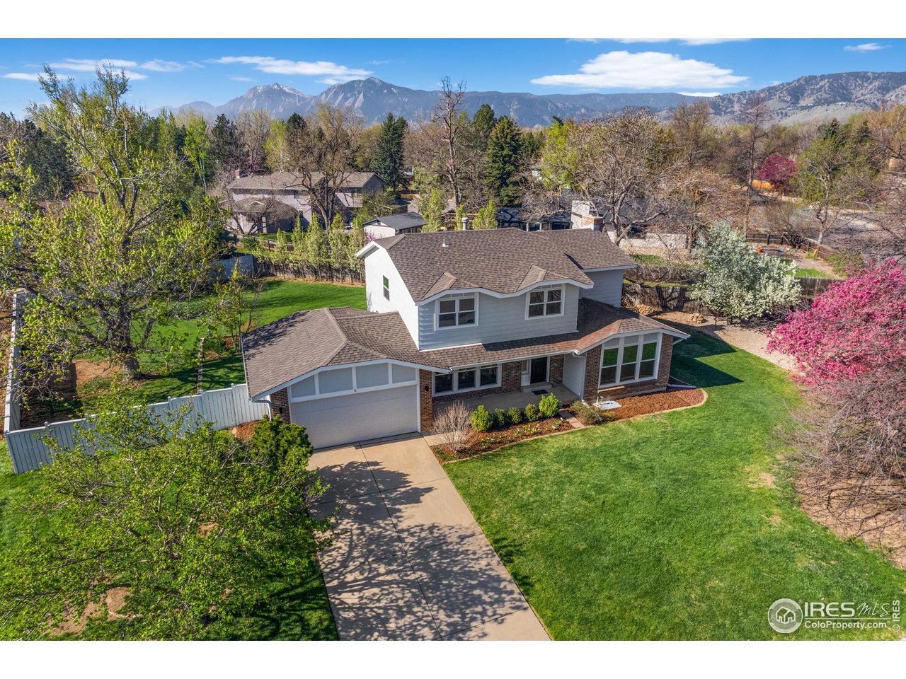 an aerial view of residential houses with outdoor space and trees