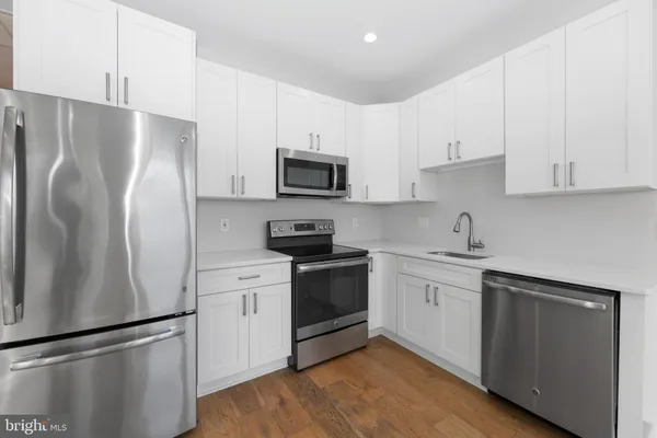 a kitchen with stainless steel appliances granite countertop white cabinets and window