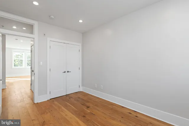 a view of an empty room with wooden floor