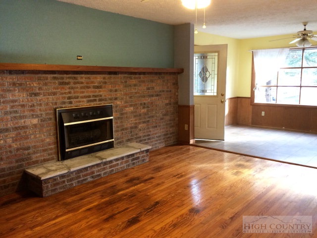 39 Painter Road Banner Elk, NC 28604 - Photo 1 of 17 an empty room with wooden floor and fireplace