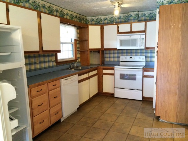 39 Painter Road Banner Elk, NC 28604 - Photo 11 of 17 a kitchen with granite countertop a sink cabinets stainless steel appliances and a window