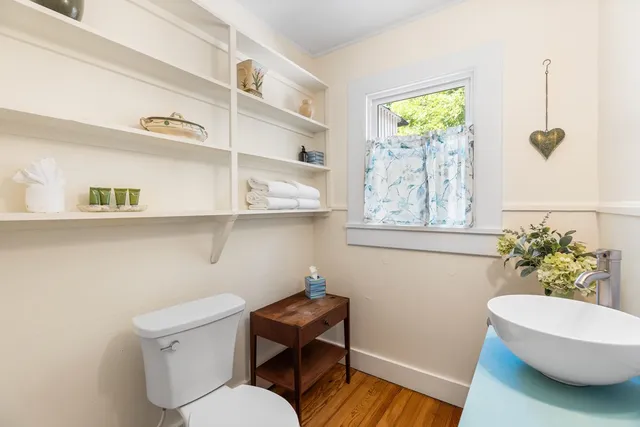 a bathroom with a toilet a sink and a window