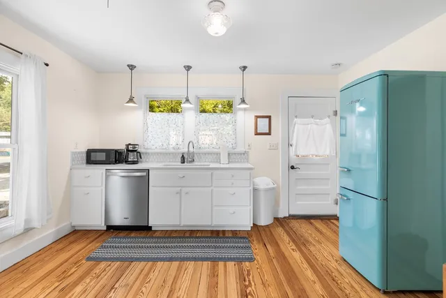 a kitchen with a refrigerator and white cabinets