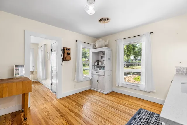 a view of a livingroom with wooden floor and a ceiling fan