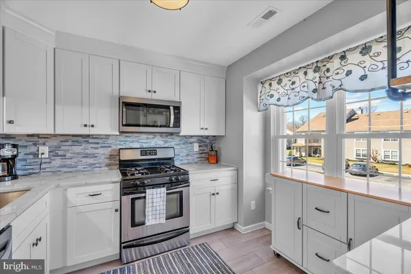 a kitchen with granite countertop white cabinets and white appliances