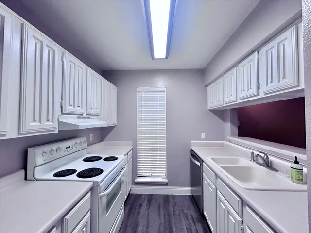 a kitchen with a sink a stove and cabinets