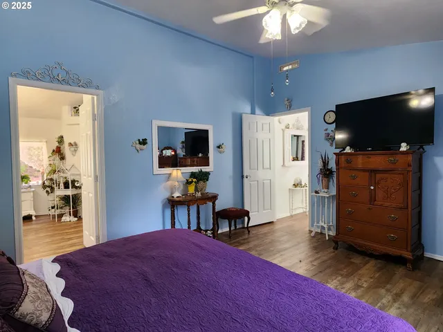 a bedroom with a bed and a flat tv screen on dresser