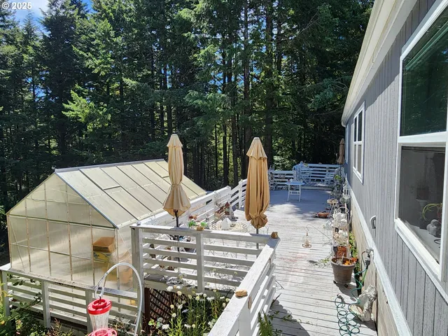 a view of a patio with table and chairs with wooden floor and fence