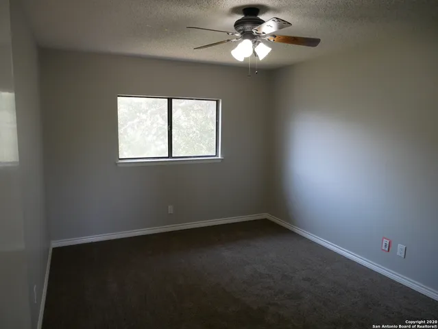 a view of an empty room with a ceiling fan