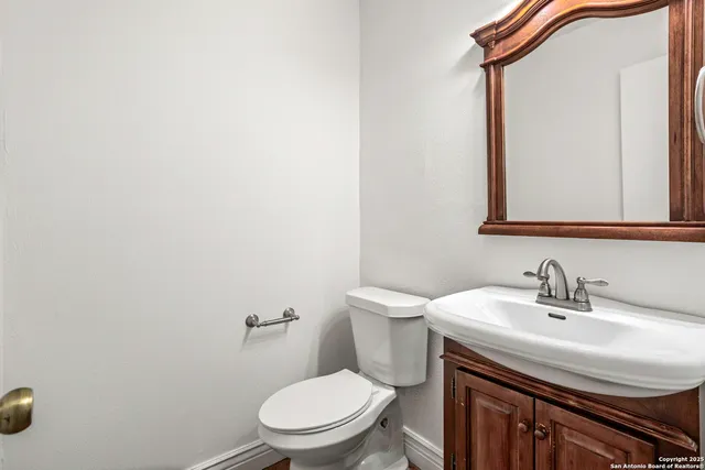 a bathroom with a toilet a sink and mirror