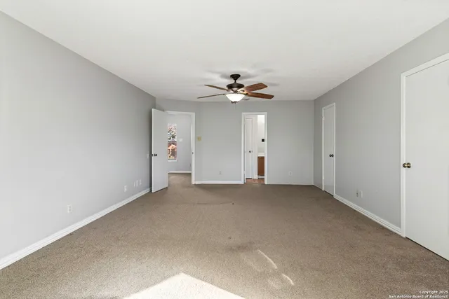 a view of an empty room with a ceiling fan