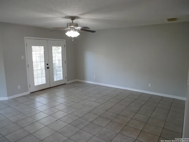 a view of a livingroom with a chandelier fan and windows