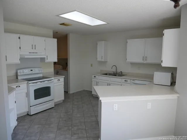 a kitchen with stainless steel appliances a stove sink and cabinets