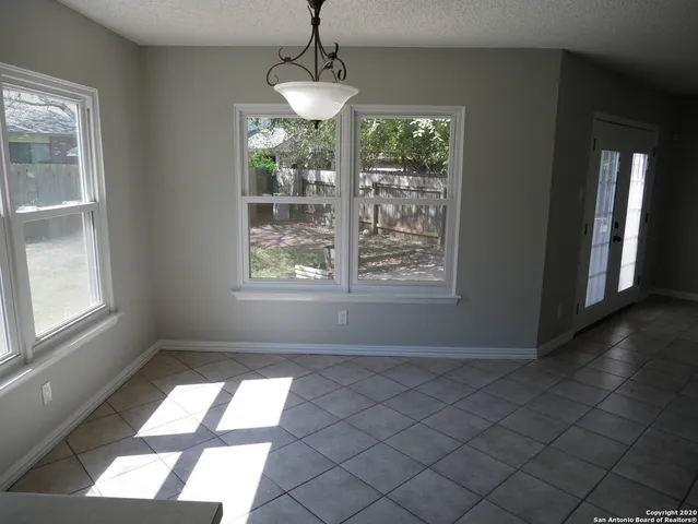 an empty room with windows and chandelier