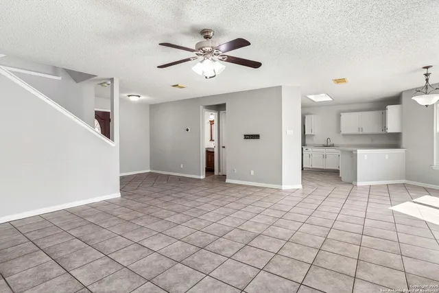 a view of a kitchen with furniture and a chandelier fan