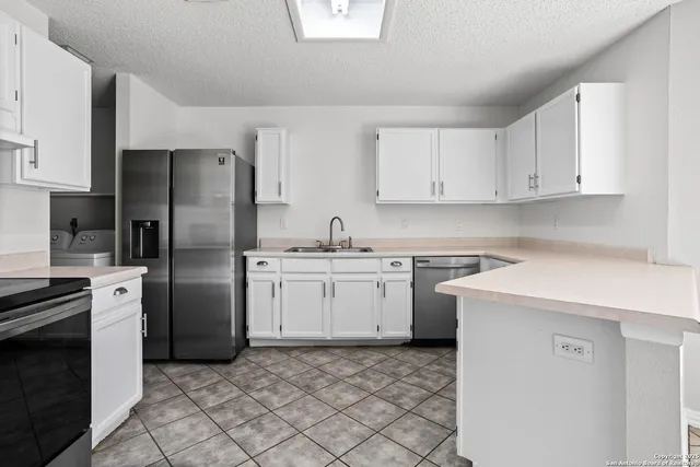 a kitchen with a refrigerator sink and cabinets