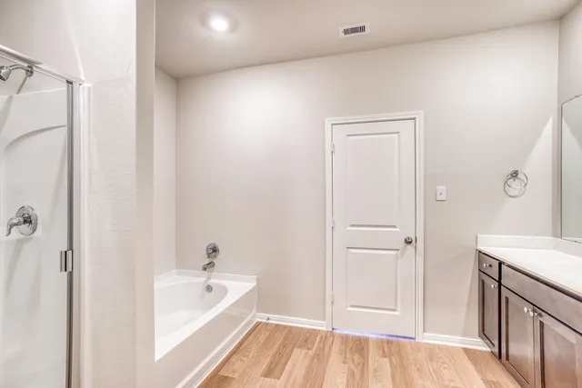 a bathroom with a tub a sink and a large mirror