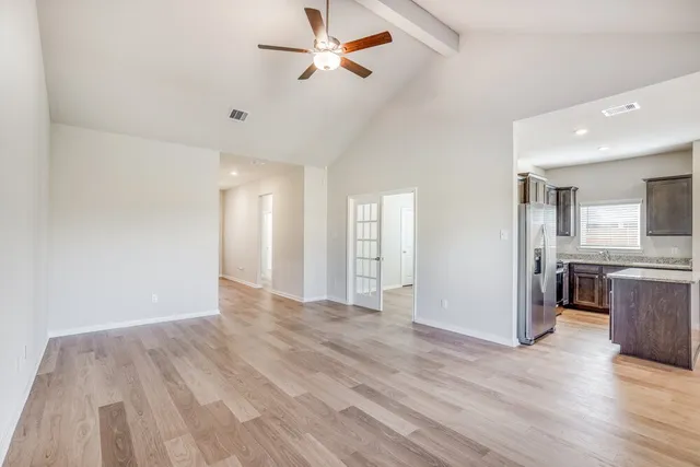 a view of a kitchen with wooden floor and a ceiling fan