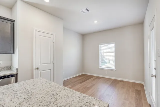 a view of a bedroom with wooden floor and window