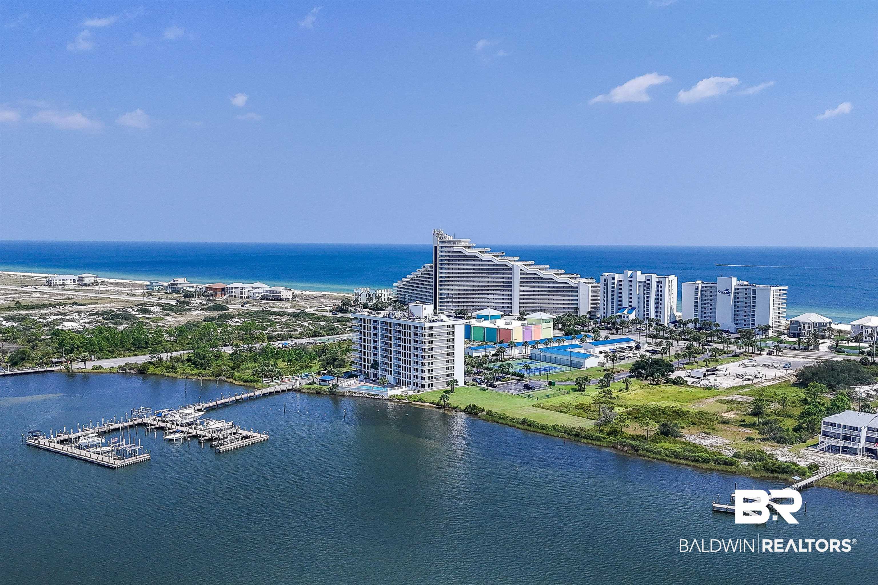 16287 Perdido Key Drive, Unit 105 Pensacola, FL 32507 - Photo 59 of 66 Coastal setting featuring a marina with multiple boat slips, a large body of water, and extensive beachfront