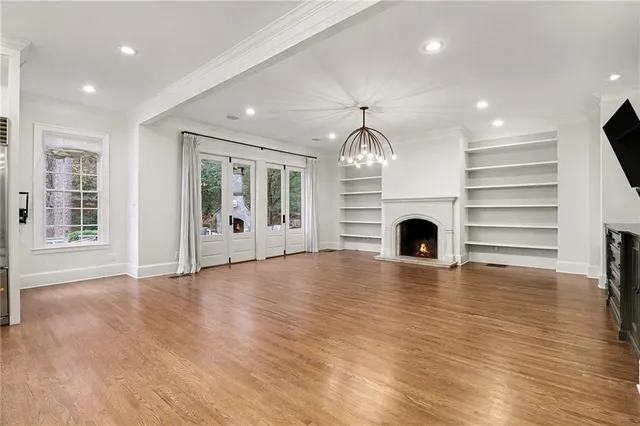 a view of empty room with wooden floor and fireplace