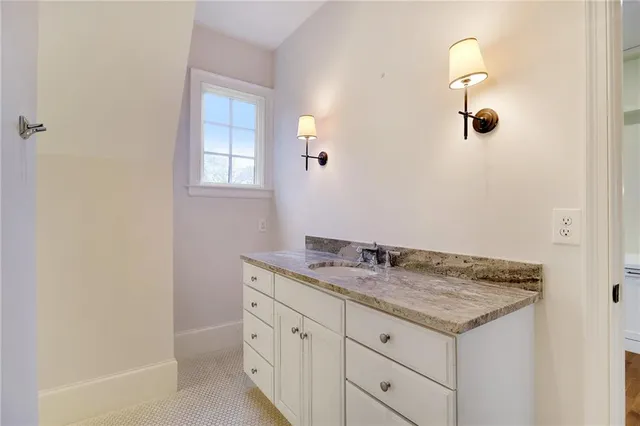 a bathroom with a granite countertop sink and a mirror